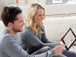 Man and a woman studying garage door controls on a tablet
