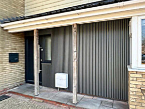 Anthracite grey front door with matching adjacent clad wall 